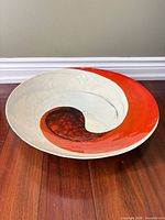Full view of round Murano glass bowl on wood floor showing coloration and size