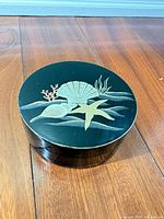 closed coaster holder showing gold marine design on lid