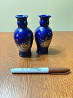 Pair of cobalt blue bud vases front view beside marker for scale