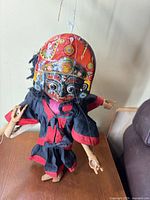 Full view of puppet hanging showing body, costume and strings
