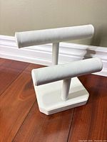Front angled view showing two white faux leather bars and base