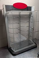 Front view of clear acrylic eyeglass display case showing locking door and interior metal rods