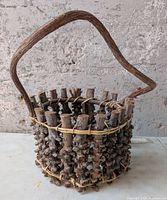 Front view of cylindrical twig basket with vine handle