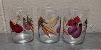 Front view of three glasses showing vegetable graphics