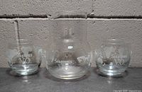 front view of carafe and two glasses showing etched design and logos
