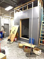 Two assembled vertical aluminum poles with black bases in warehouse setting