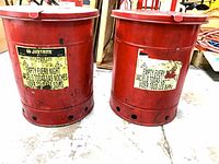 two red Justrite oily waste cans front view showing labels and vent holes