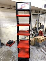 Front view of one shelving unit showing five red trays and Liqui Moly header