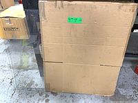 Three clear plexiglass sheets leaned against cardboard