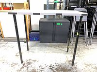 Front view of one high-top table showing grey top, black legs, underframe cabinet not included