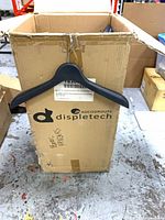 Closed box showing external branding and one sample hanger for scale