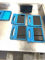 Four tablets in blue cases and one bare tablet on workstation