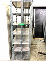 Front view of grey metal shelving rack showing upright perforated supports and eight shelves