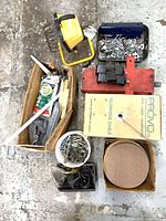 Top view of all items including jack, work light, cable box, sanding discs, fasteners