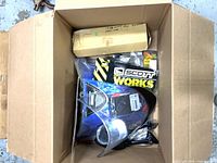 Box with assorted motorcycle parts including mirrors, packaging and hardware
