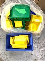 Bag containing assorted yellow, green, blue plastic bins plus blue tote