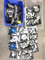 Overview of blue bin with Vortex decals and clear bin with packaged aluminum parts on floor