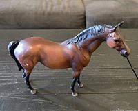 Left side view of Breyer bay horse model showing overall form and paint wear