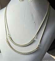 Front view of double-strand gold-tone necklace displayed on bust