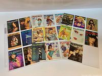Twenty-five Playboy trading cards laid out showing cover artwork
