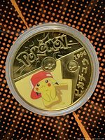 Obverse of gold-colored coin with full-color Pikachu, Pokémon logo and 1996 date