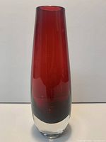 front view of red glass vase showing clear base and overall height