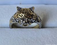 Frontal view of two-tone tiger head ring on display pad