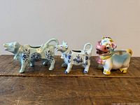 All three cow creamers side by side on tabletop