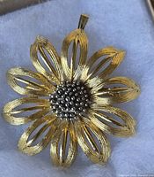 Front view showing gold-tone openwork petals and silver-tone beaded centre