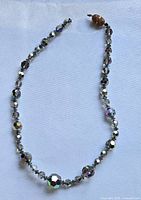 Full view of broken iridescent faceted glass bead necklace