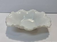 top angled view showing ruffled rim and interior of white milk glass bowl