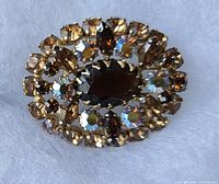 Front view of gold-tone oval brooch showing rhinestone arrangement