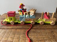Overall view of wooden stacking pull train with clown street cleaner behind