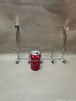 Front view of chrome metal over-the-door rack with six double hooks, soda can for scale