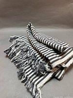 Folded striped throw blanket with fringe visible