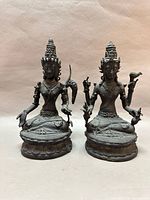 Front view of both bronze deity sculptures on lotus bases