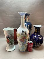 Group shot of five repaired vases with size reference can