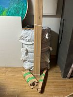 Full sealed bundle of oak flooring standing upright with loose extras bundled by green strapping