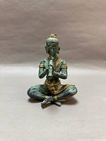 Front view of seated deity flute statue