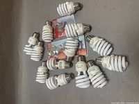 Group of CFL bulbs and two blister packs of mini bulbs on surface