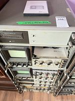 Full rack showing multiple HP modules, two CRT displays, preselector and plug-ins