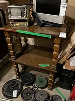End table with TV sitting on top, weight plates nearby