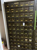 Full view of tall metal 72-drawer cabinet with labelled drawers