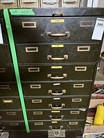 Front view of olive metal cabinet with nine drawers