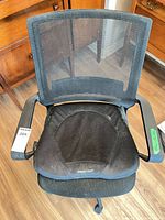 Front view of black mesh office chair with ObusForme cushion attached