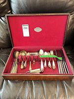 Open wooden chest displaying mixed flatware