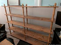 Full view of wooden shelving unit showing all shelves and uprights