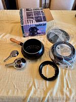 Fondue pot, burner rings in packaging, two stainless ladles, box