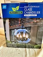 Retail box front showing Wilson & Fisher remote-controlled glass chandelier