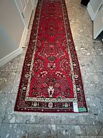 Full view of the red Persian runner rug on tiled floor